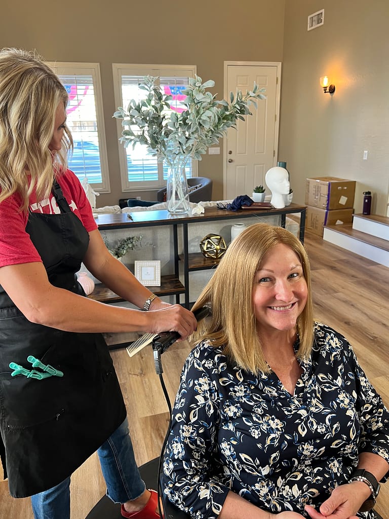 woman and her hair stylist curling her custom wig